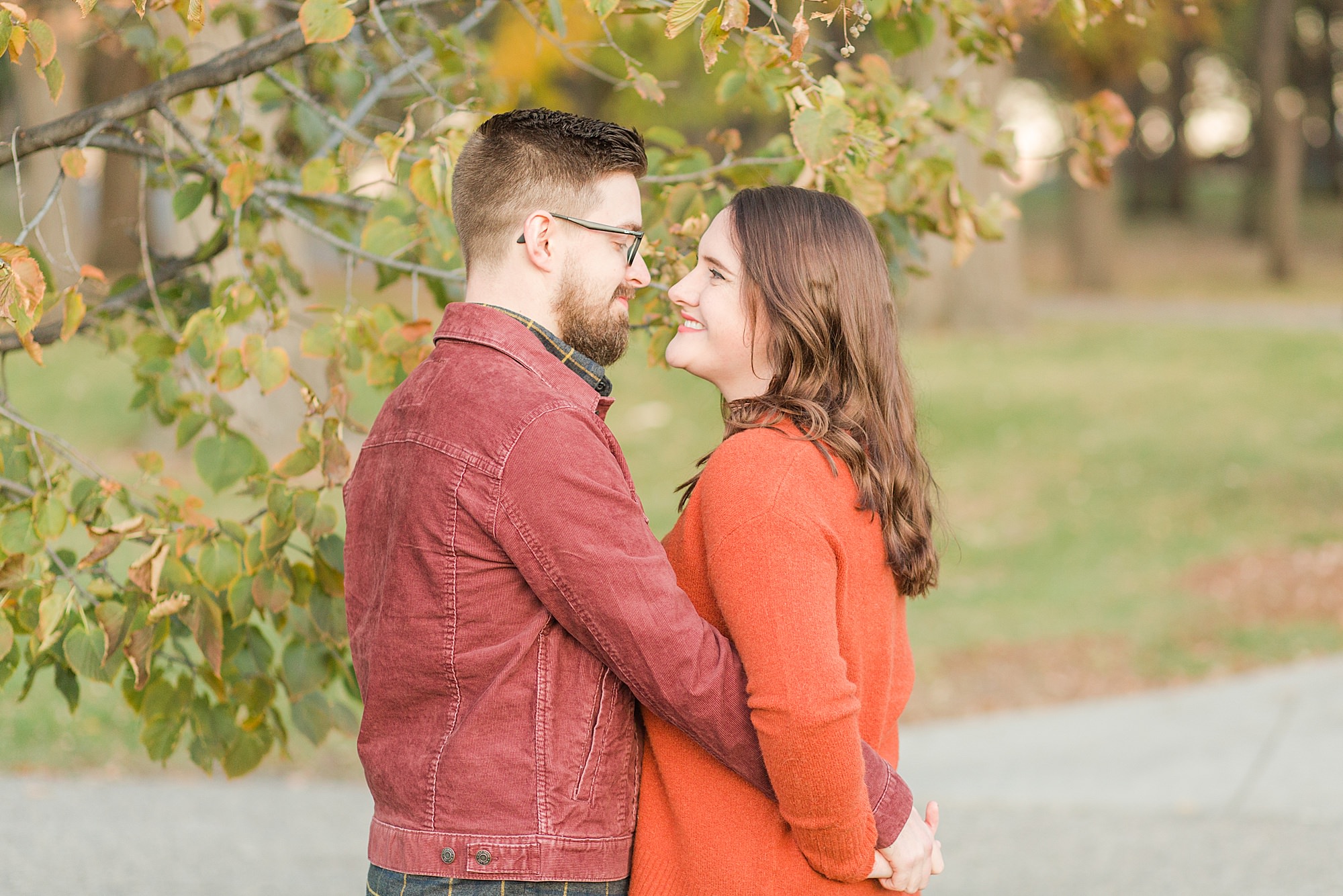 Couple in a park holding hands in shades of orange and red