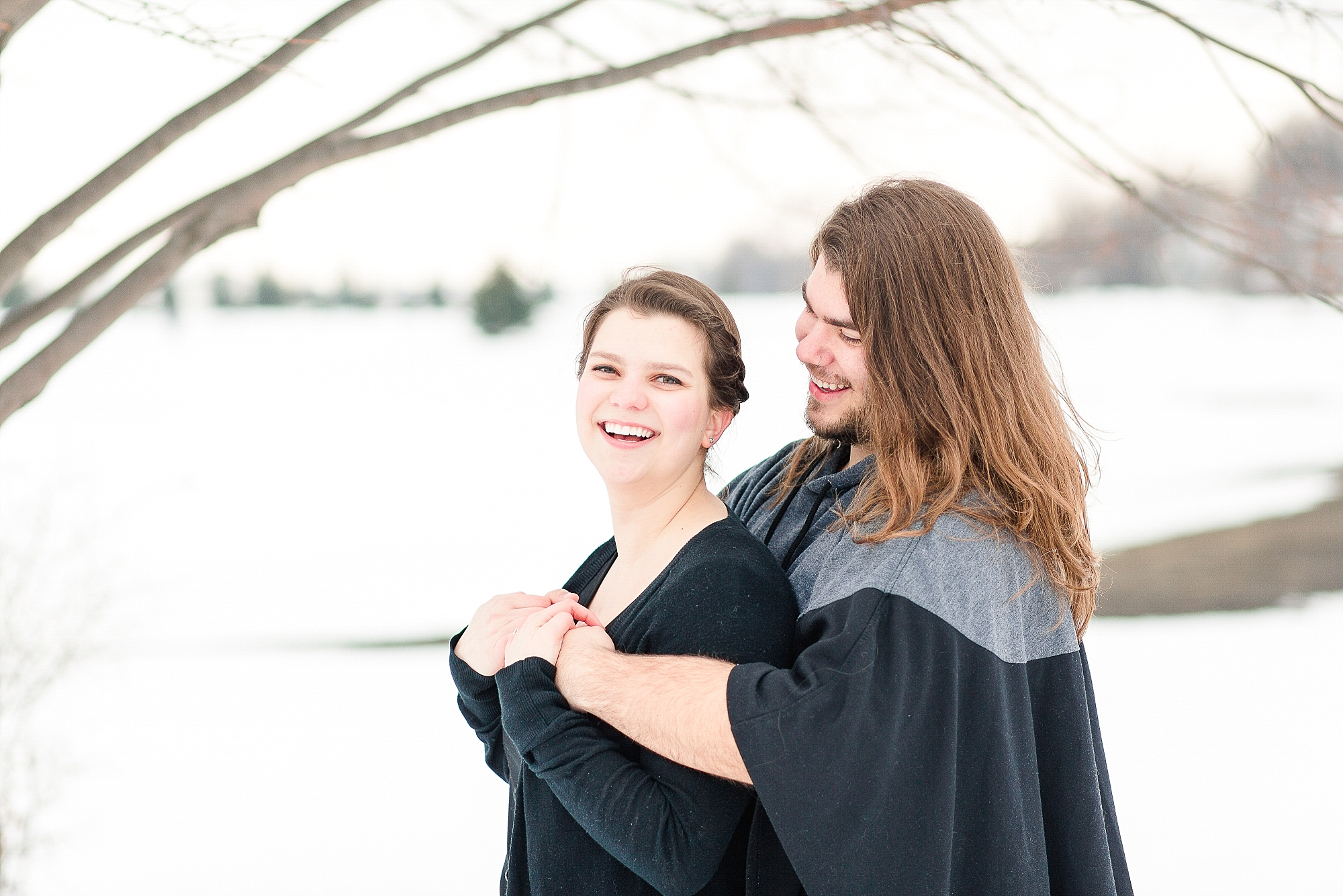 Smiling engagement photos in winter wonderland