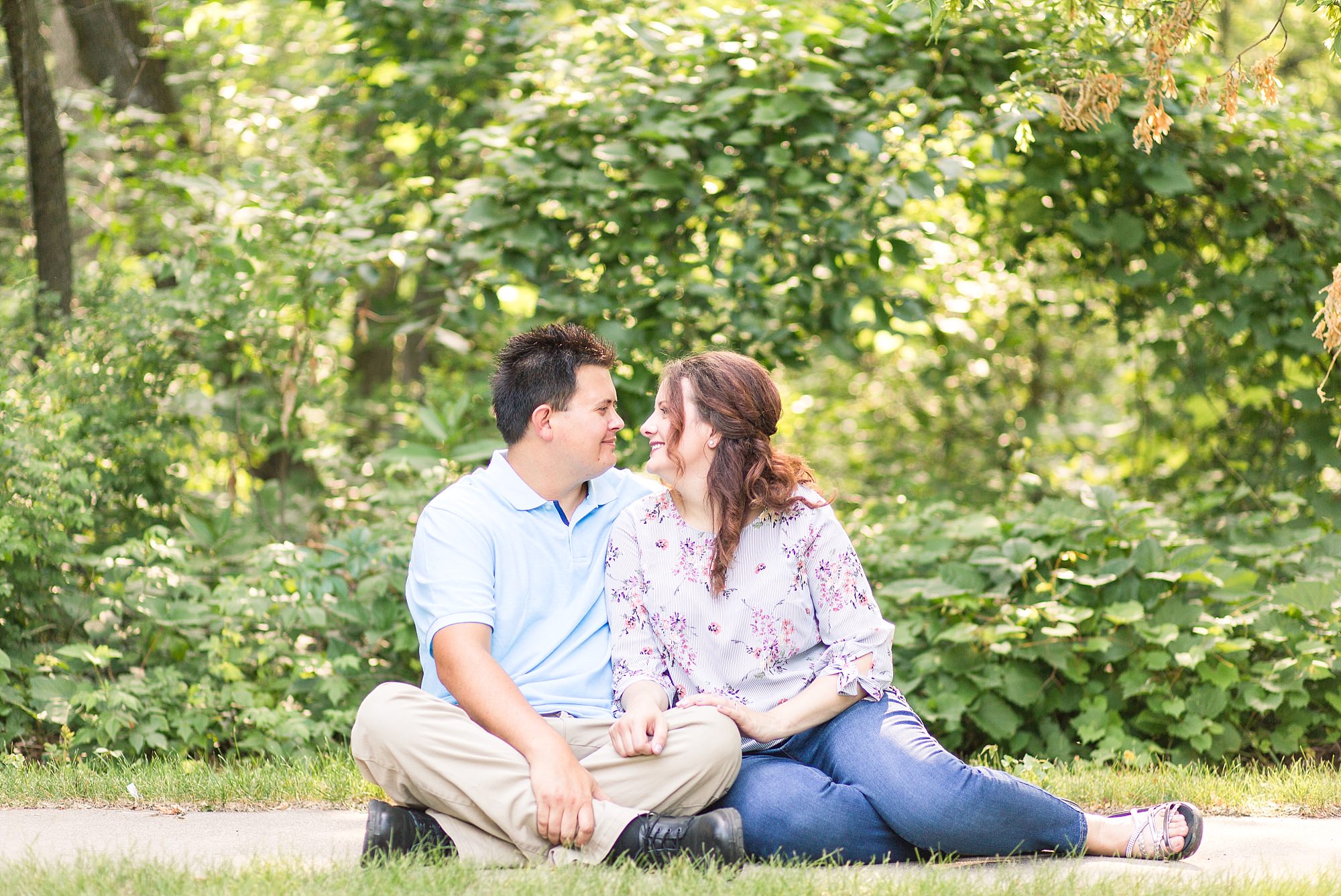 Engaged couple sit and smile at Buffalo State Park