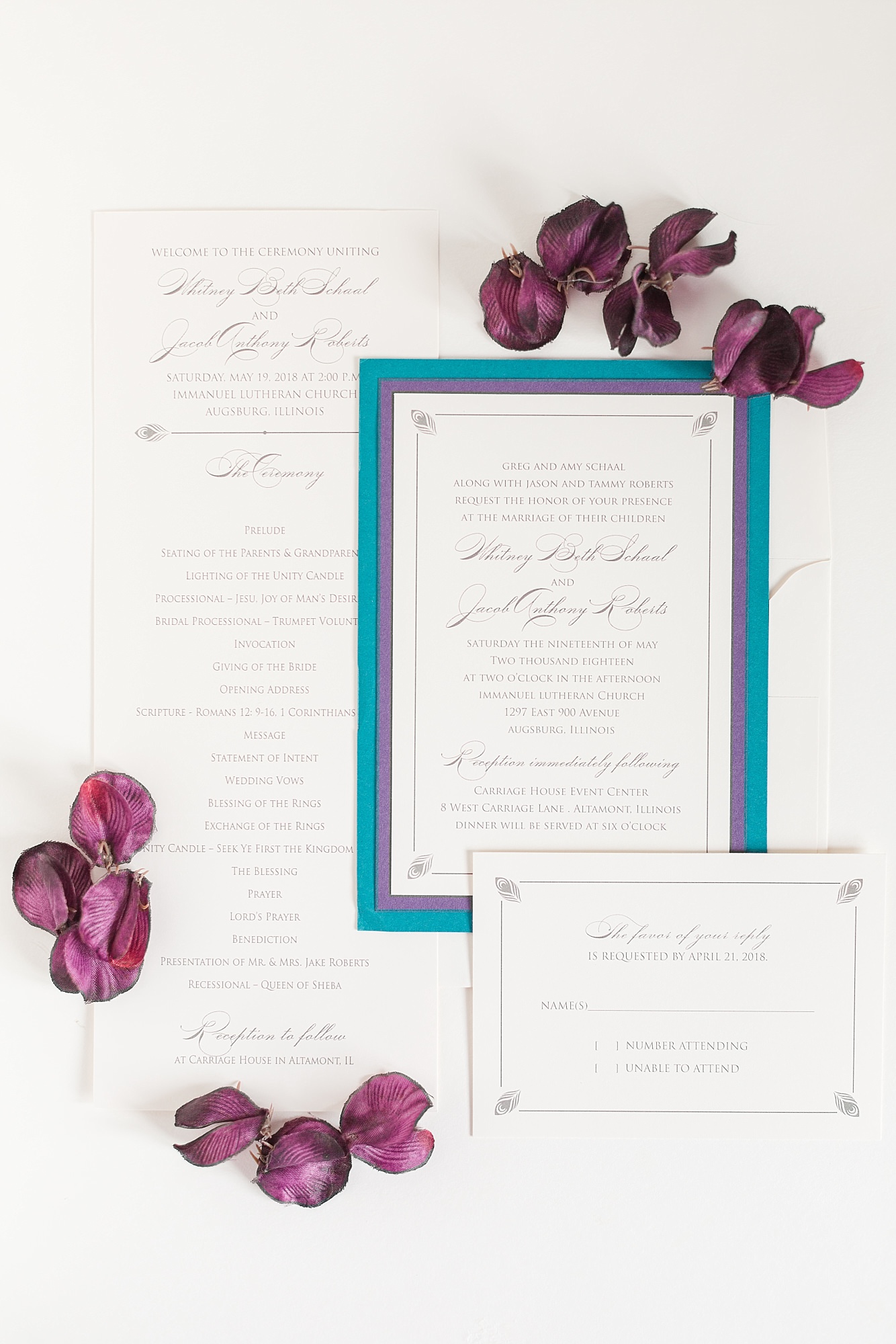 White wedding invites with purple and blue edging and peacock feather details