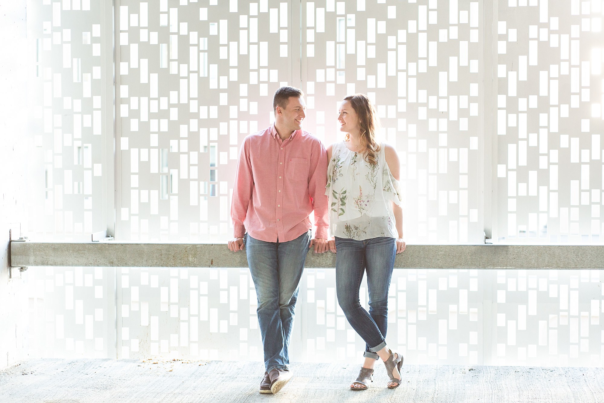 A couple wears a mix of pink, florals, and jeans for their Downtown Fargo engagement session