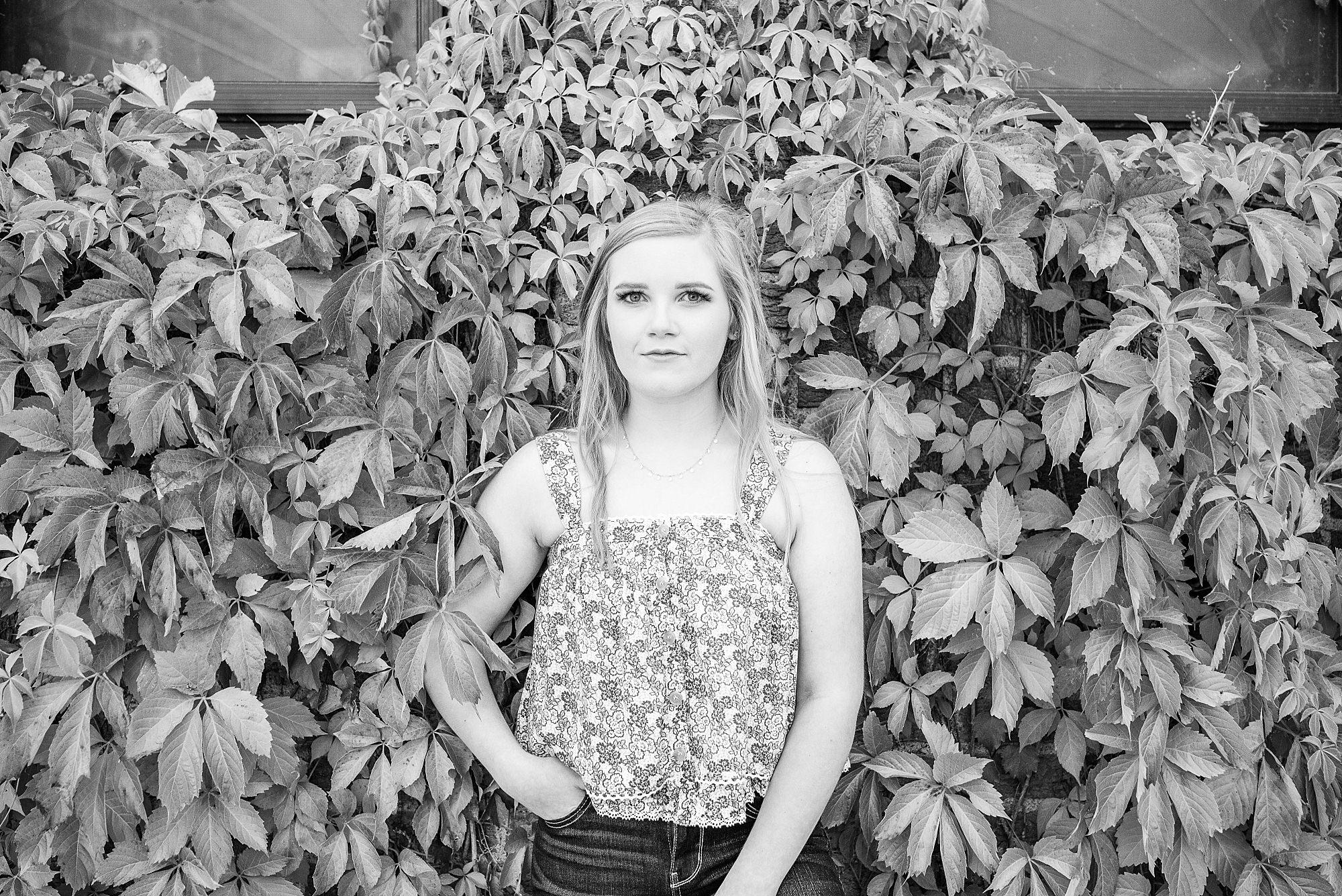 black and white Senior Portraits in Fargo against ivy wall
