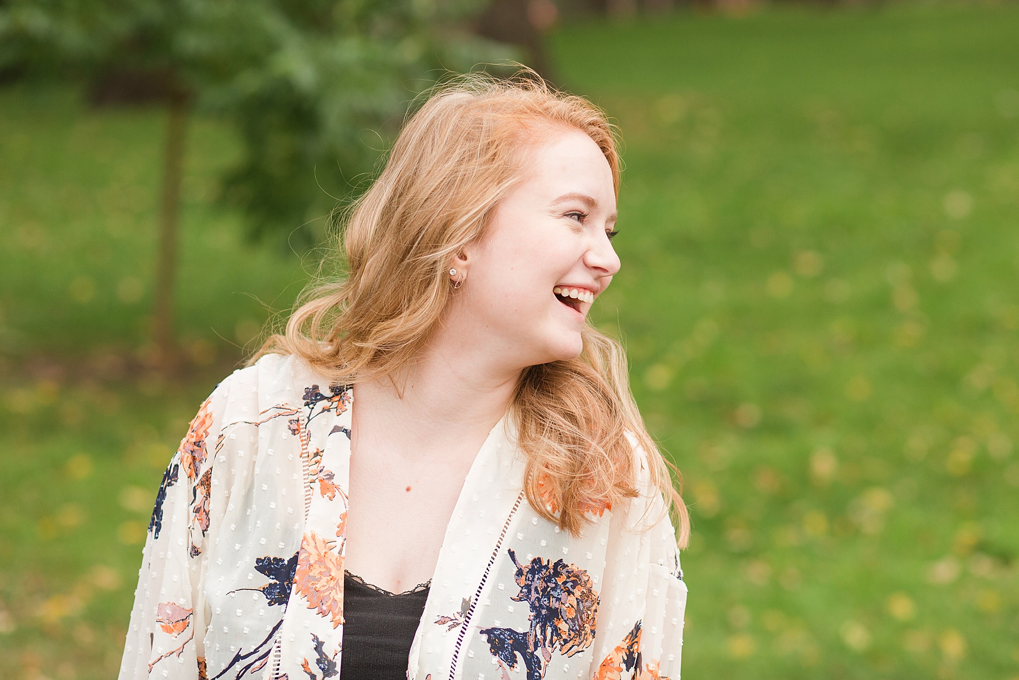 Senior girl laughs over her shoulder during her senior photo session in Fargo