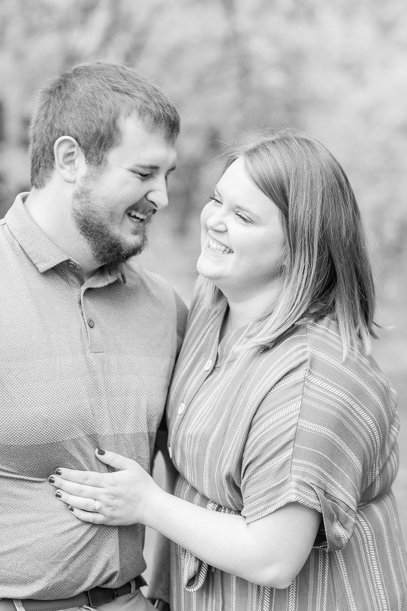 An engaged couple laugh at each other during their engagement session