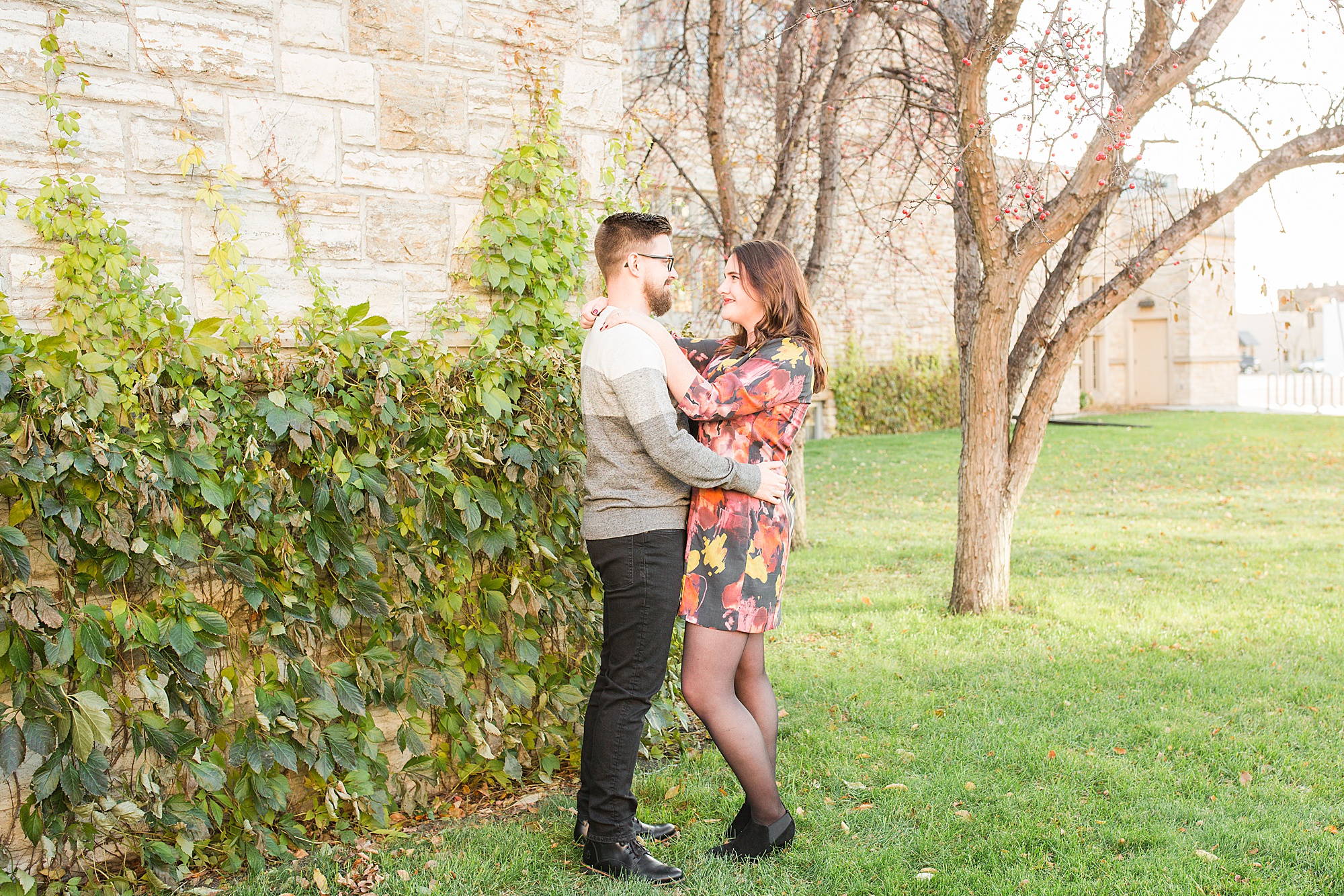 Couple in colorful dress and grey sweater pose for their fall engagement session