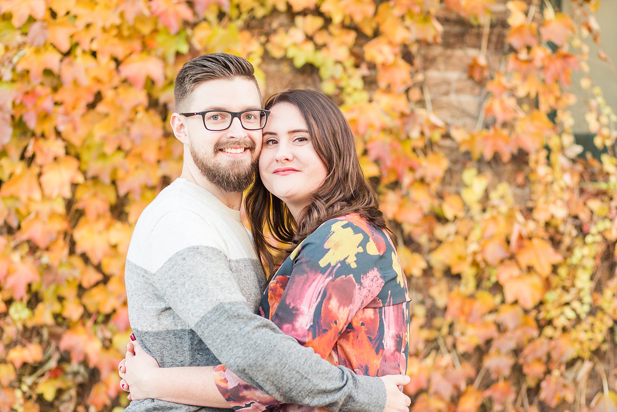 Orange fall leaves behind a couple pop during this colorful fall engagement session
