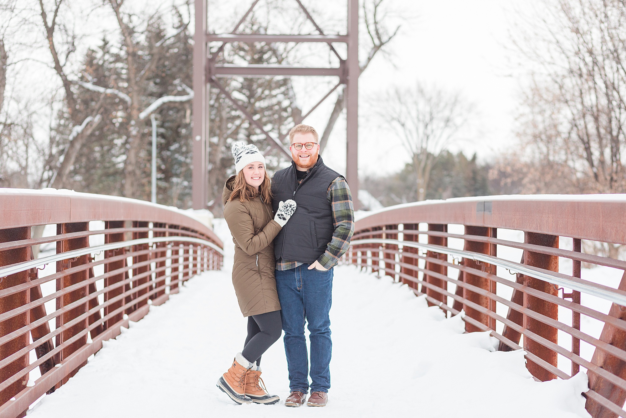 A couple in warm winter gear shows off that Lindenwood is one of the Best Places to take Engagement Photos in Fargo during the wintertime.