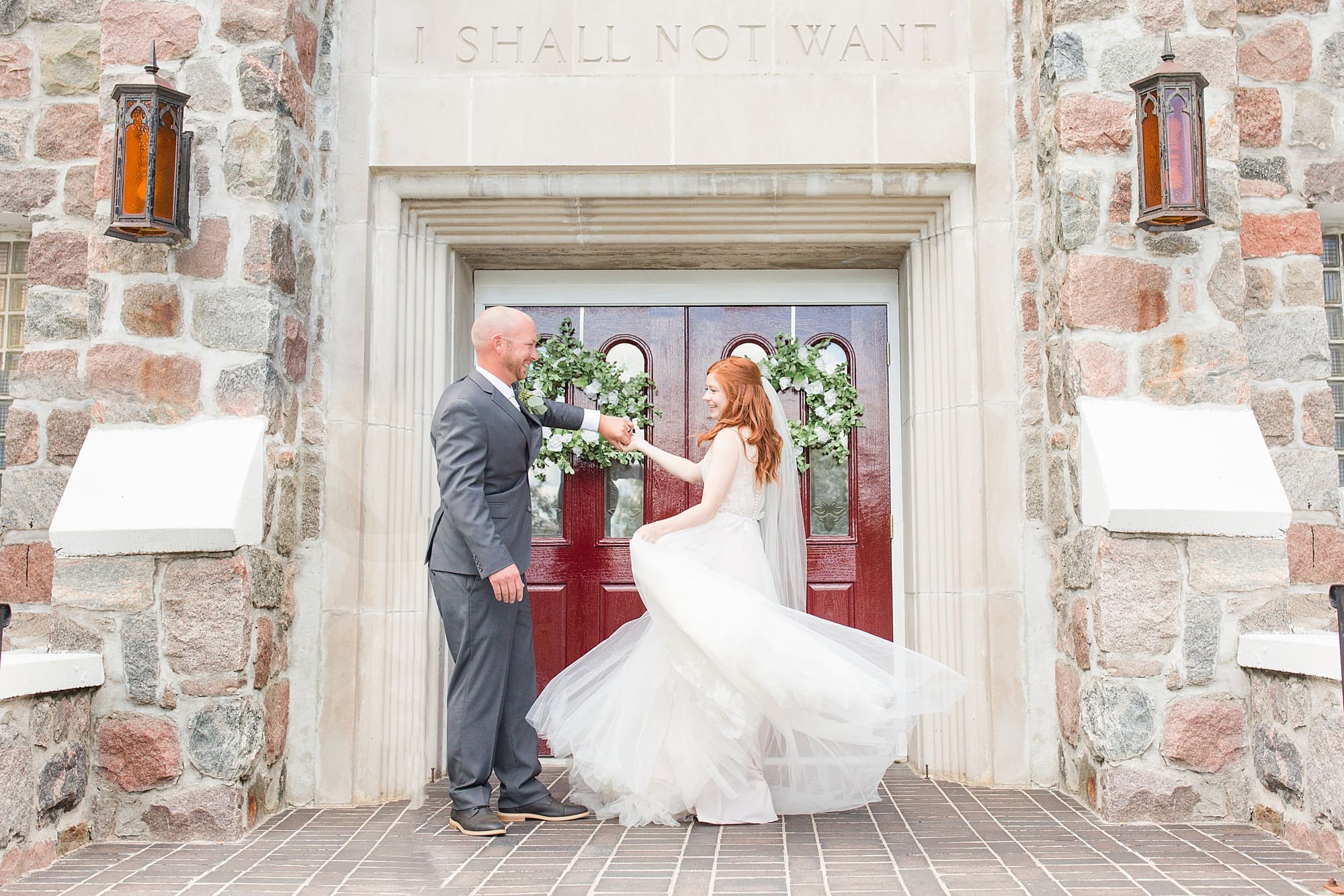 A bride and groom dance outside the front doors of their small town wedding church