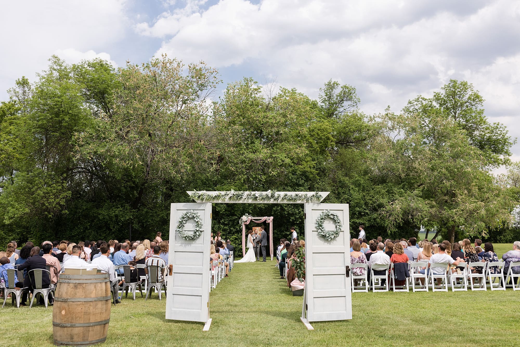 Outdoor Summer Wedding at Legacy Acres with doors leading to the aisle 