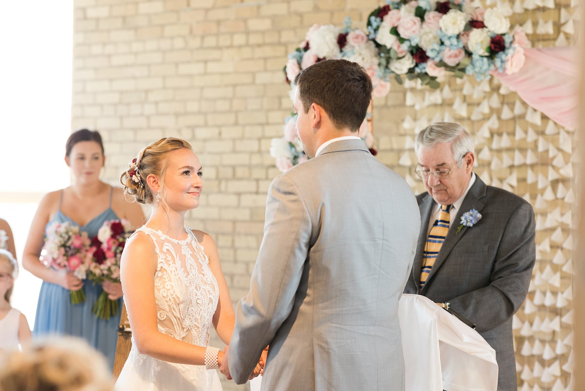 Bride smiles at her groom during their Plains Art Museum wedding ceremony