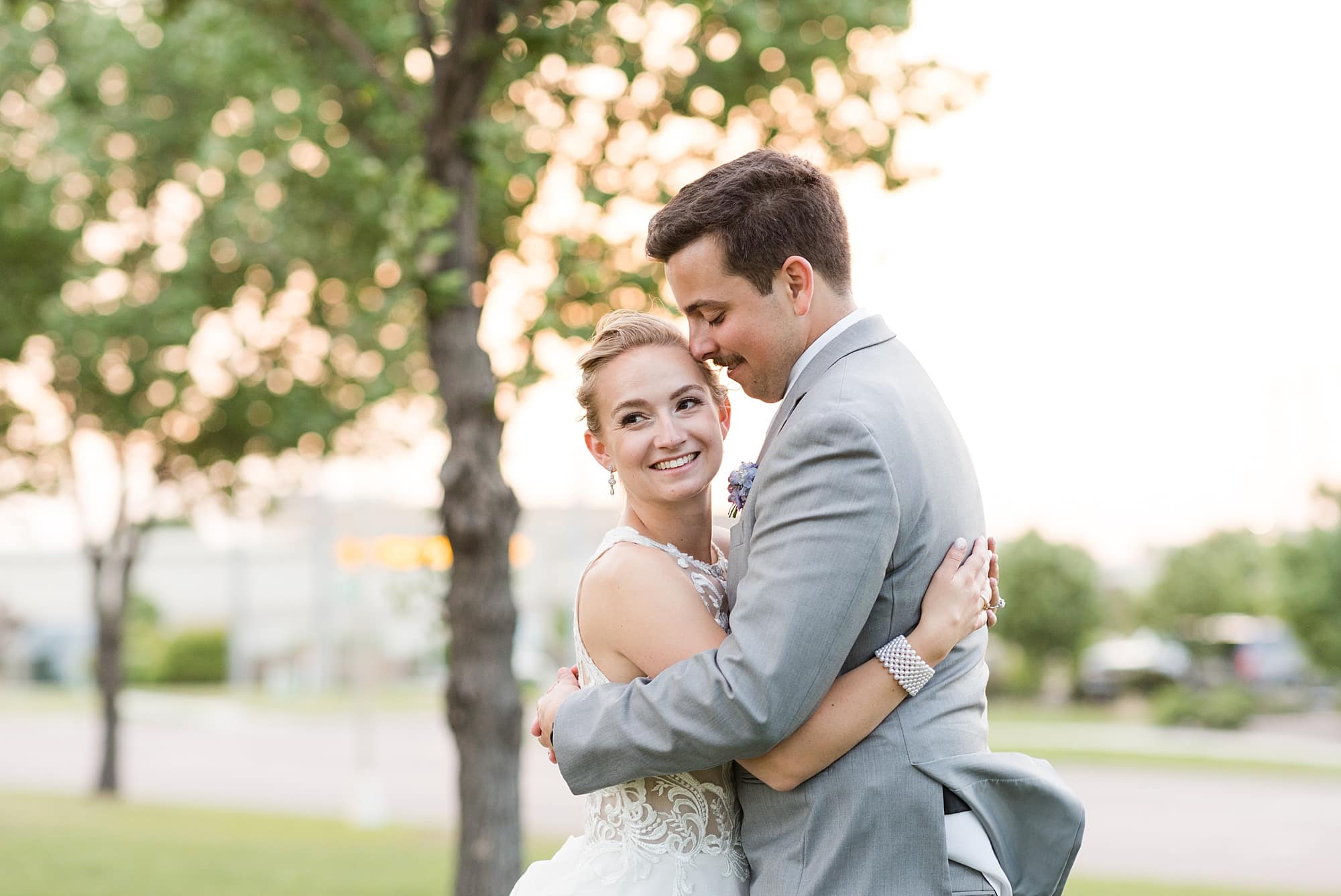 Bride and groom smile as the sunset sets behind them during their sunset photos at Hilton Garden Inn