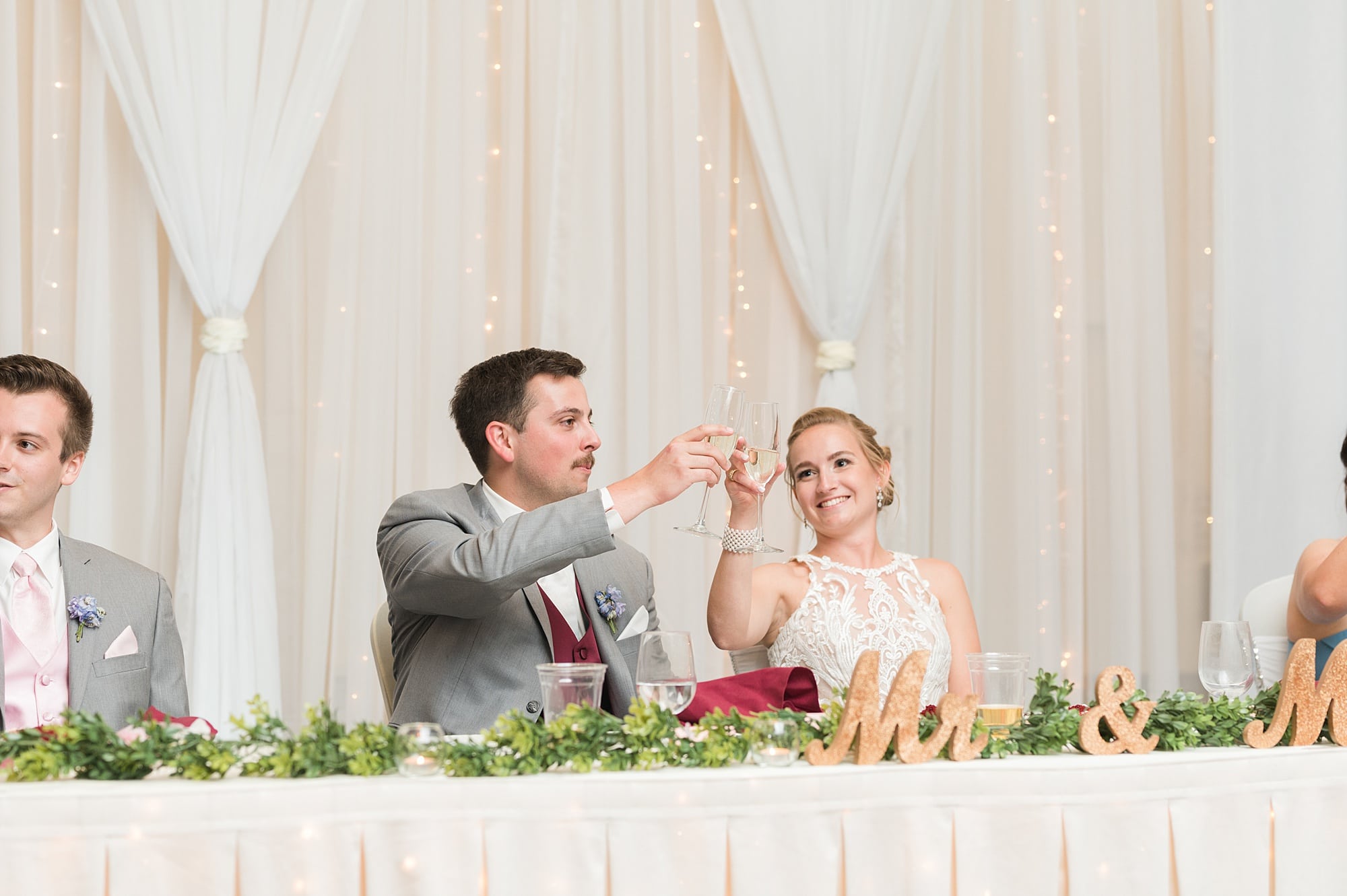 Bride and Groom cheers and smile during the speeches at the Hilton Garden Inn
