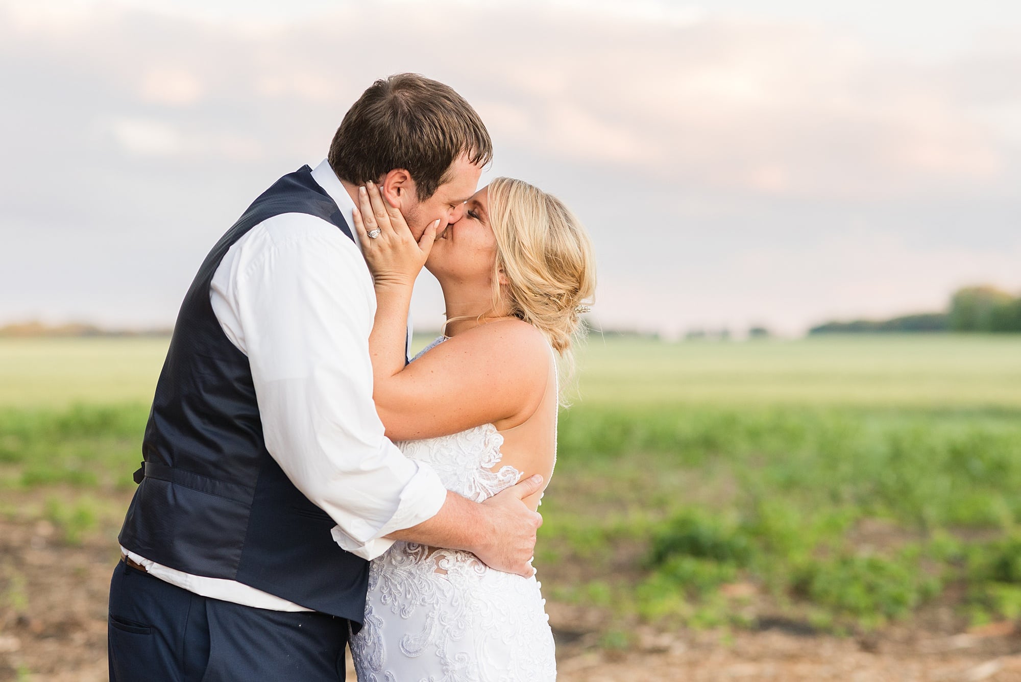 Newlywed couple kisses at Naastad Acres during sunset