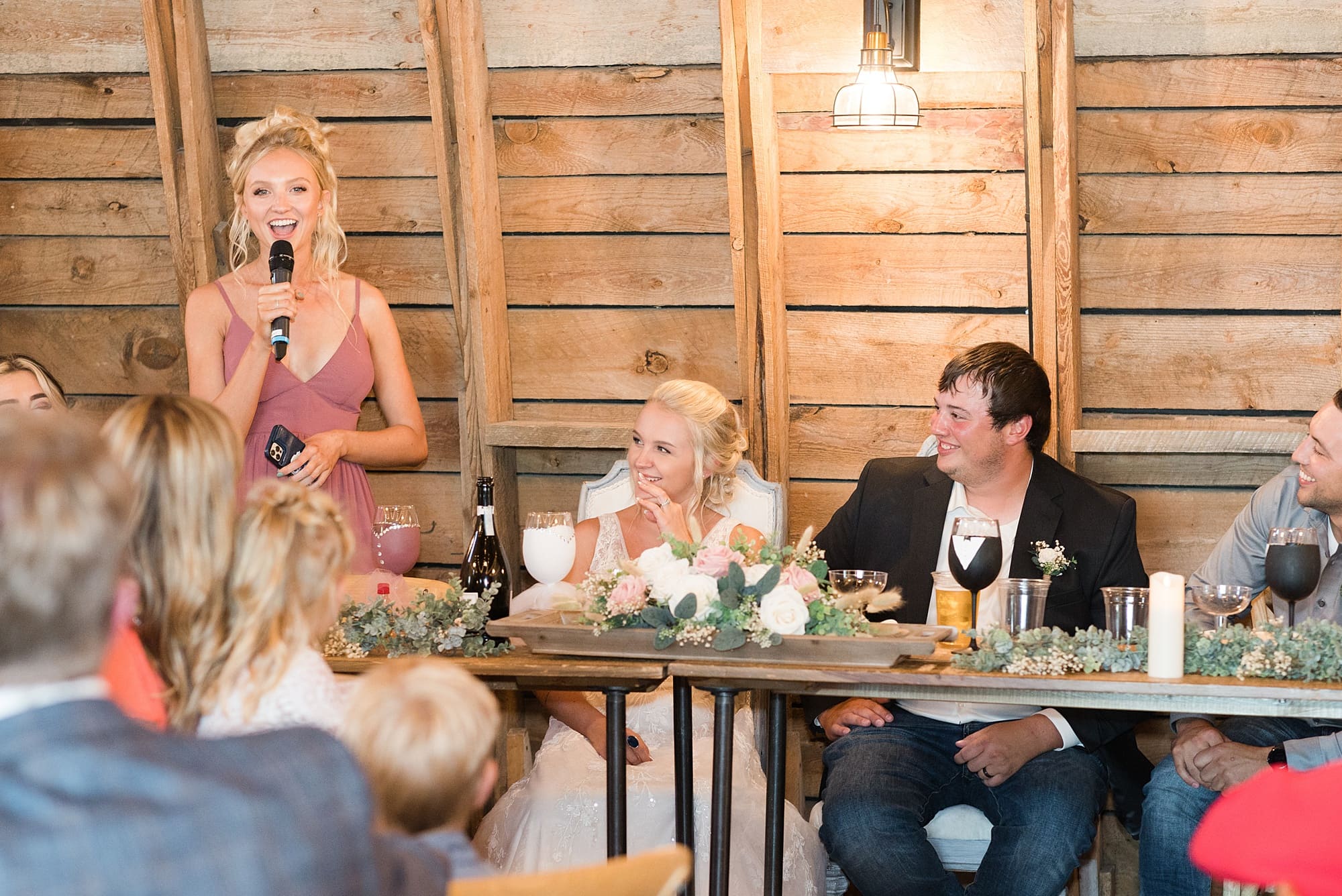 Maid of Honor in mauve colored dress gives her speech during a summer wedding at Rustic Oaks