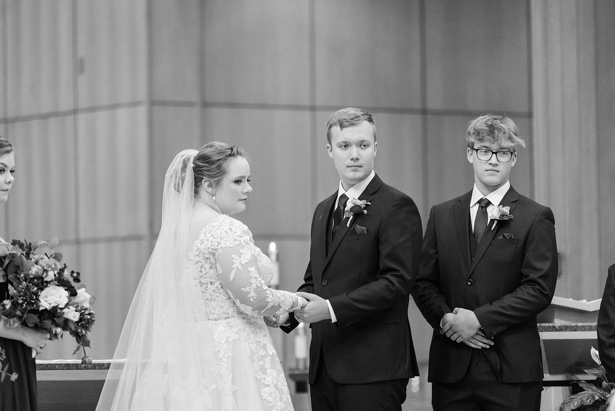 Bride and groom hold hands during their wedding ceremony at St. Joseph's Catholic Church