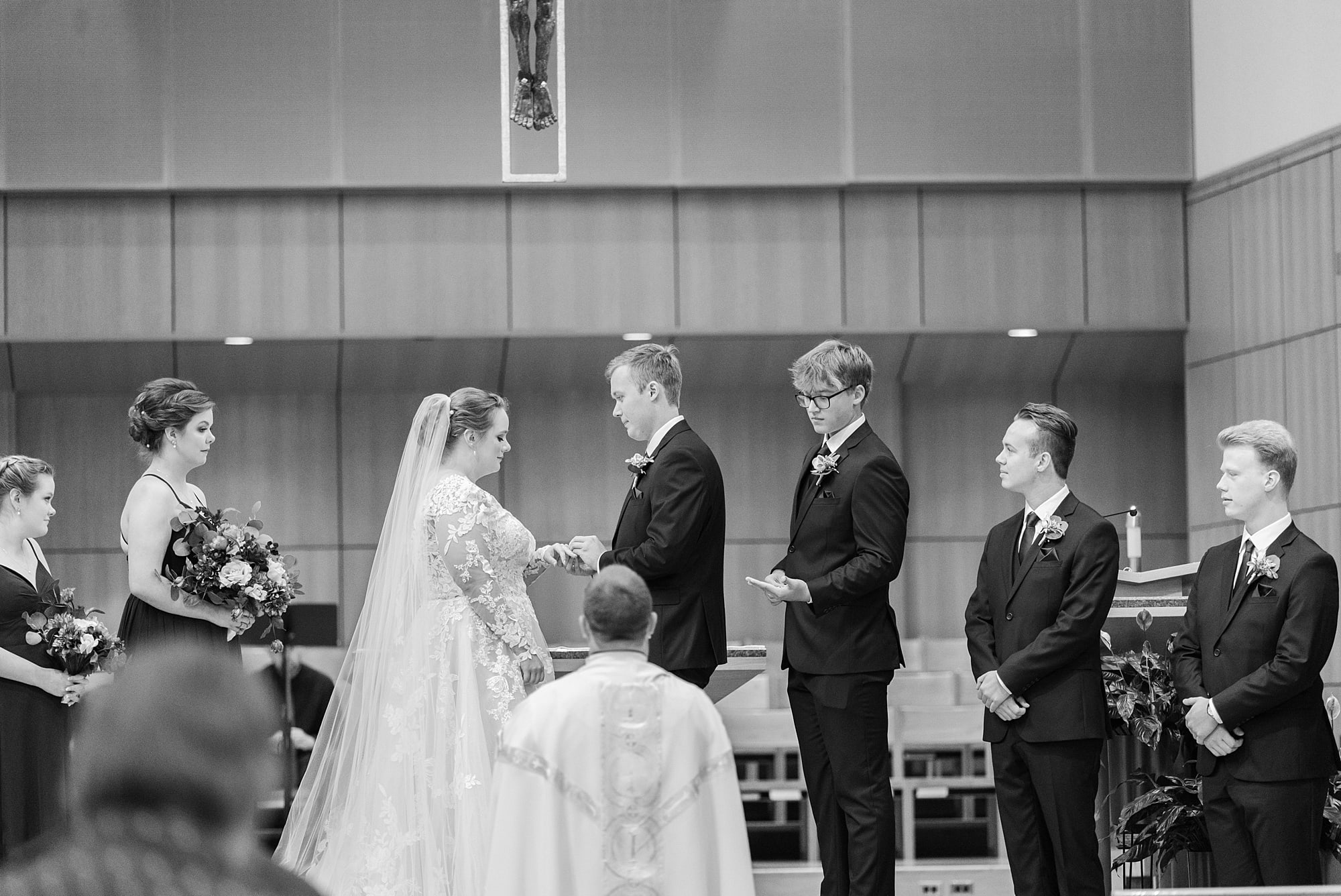 Best man hands the couple their rings at their wedding at St. Joseph's Catholic Church