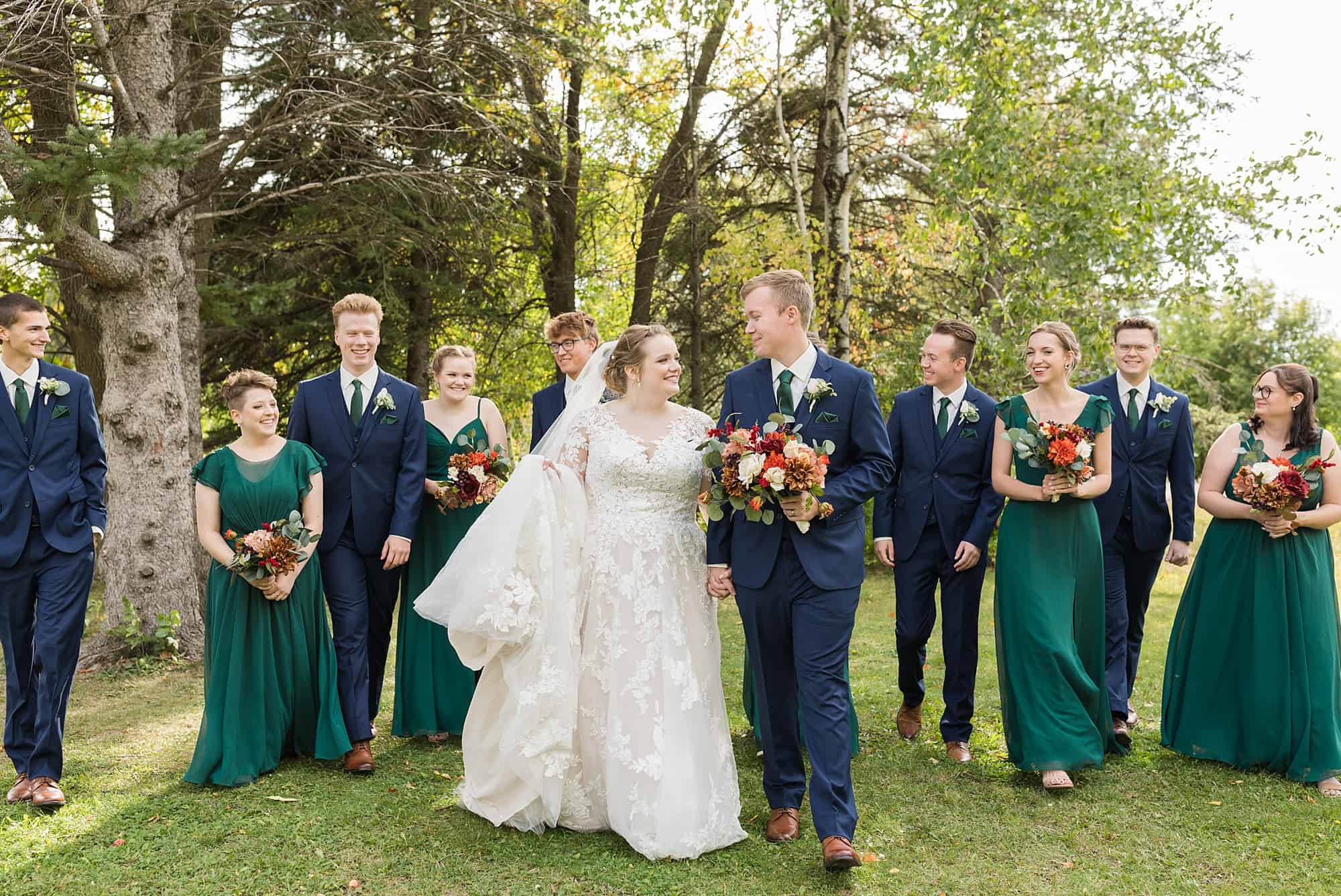 Wedding party walks together at Orchard Glen Park during the fall