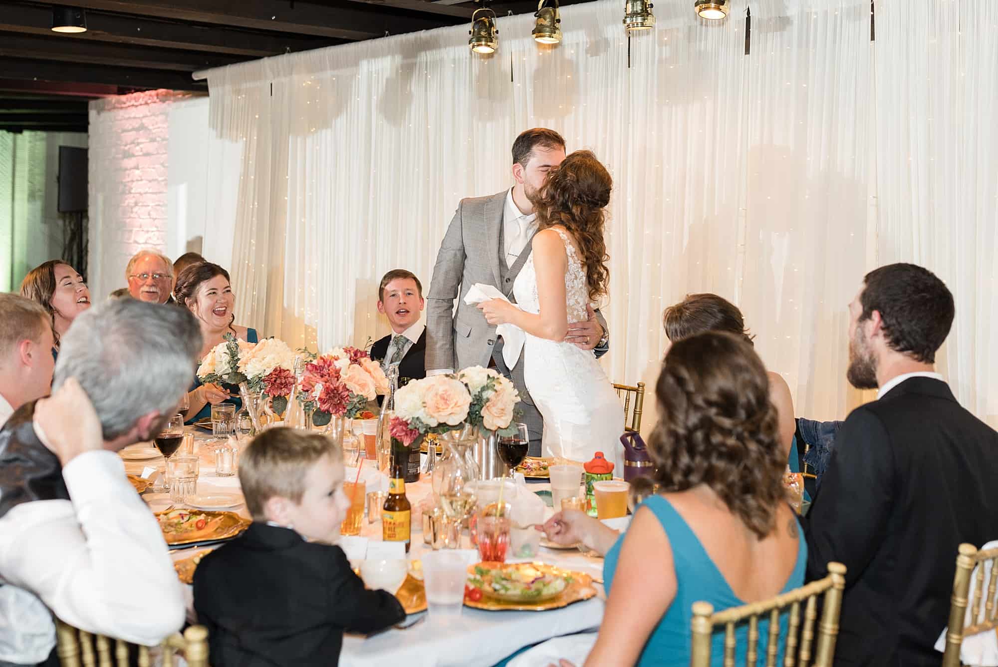 Newlyweds share a kiss during their Chanhassen Dinner Theater wedding reception
