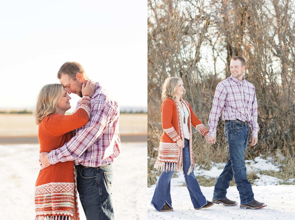 Couple in plaid and orange holds hands and walk along the winter farm during their engagement session.
