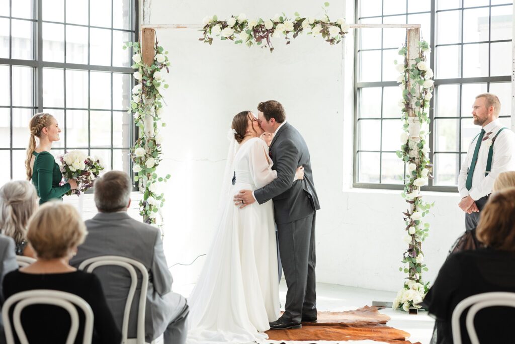 Bride and Groom share their first kiss at Ivy & Rose Warehouse in Fargo, ND