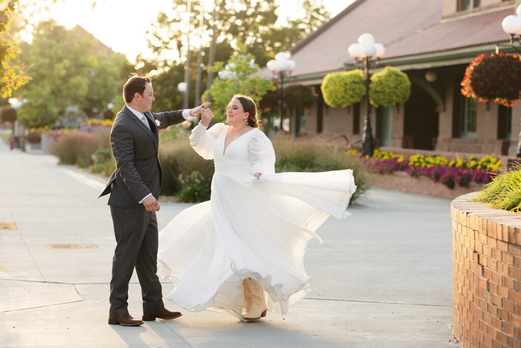 Groom twirls his bride in Downtown Fargo at Sunset