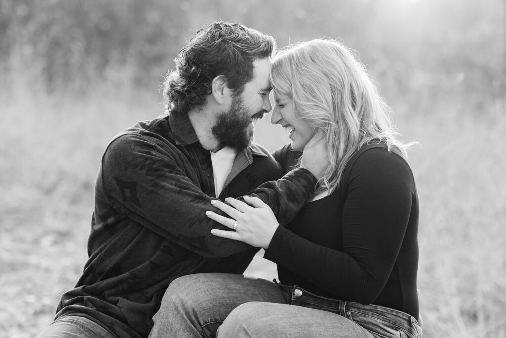 Couple laugh and hold each other during their Engagement Photos at Forest River Park