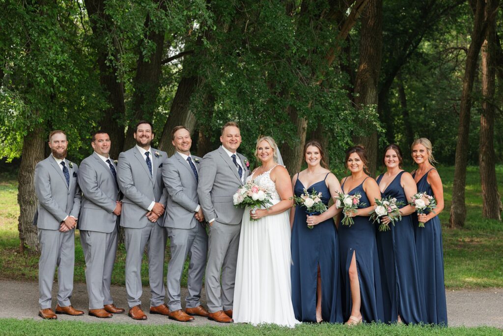 Wedding party in gray and navy smile for photos during a summer wedding at Carlos Creek Winery
