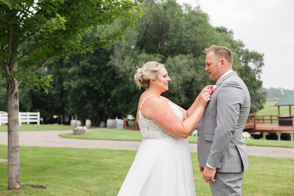 Bride fixes her grooms flowers during their first look at their wedding at Carlos Creek Winery